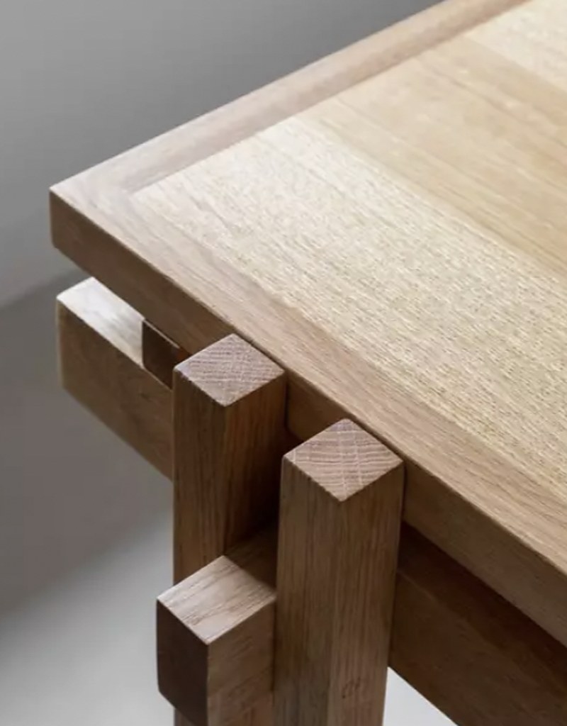 Japanese-style light oak corner joinery — through-tenon legs meeting a clean tabletop